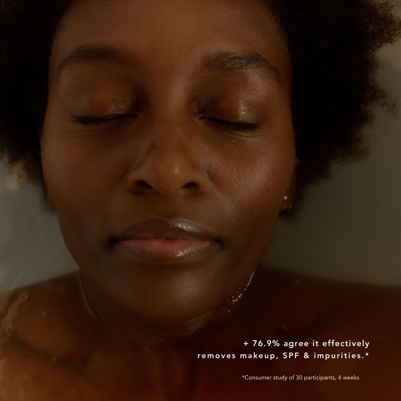 Close-up of a woman with a neutral expression, water droplets on her skin, with text about skincare product effectiveness.