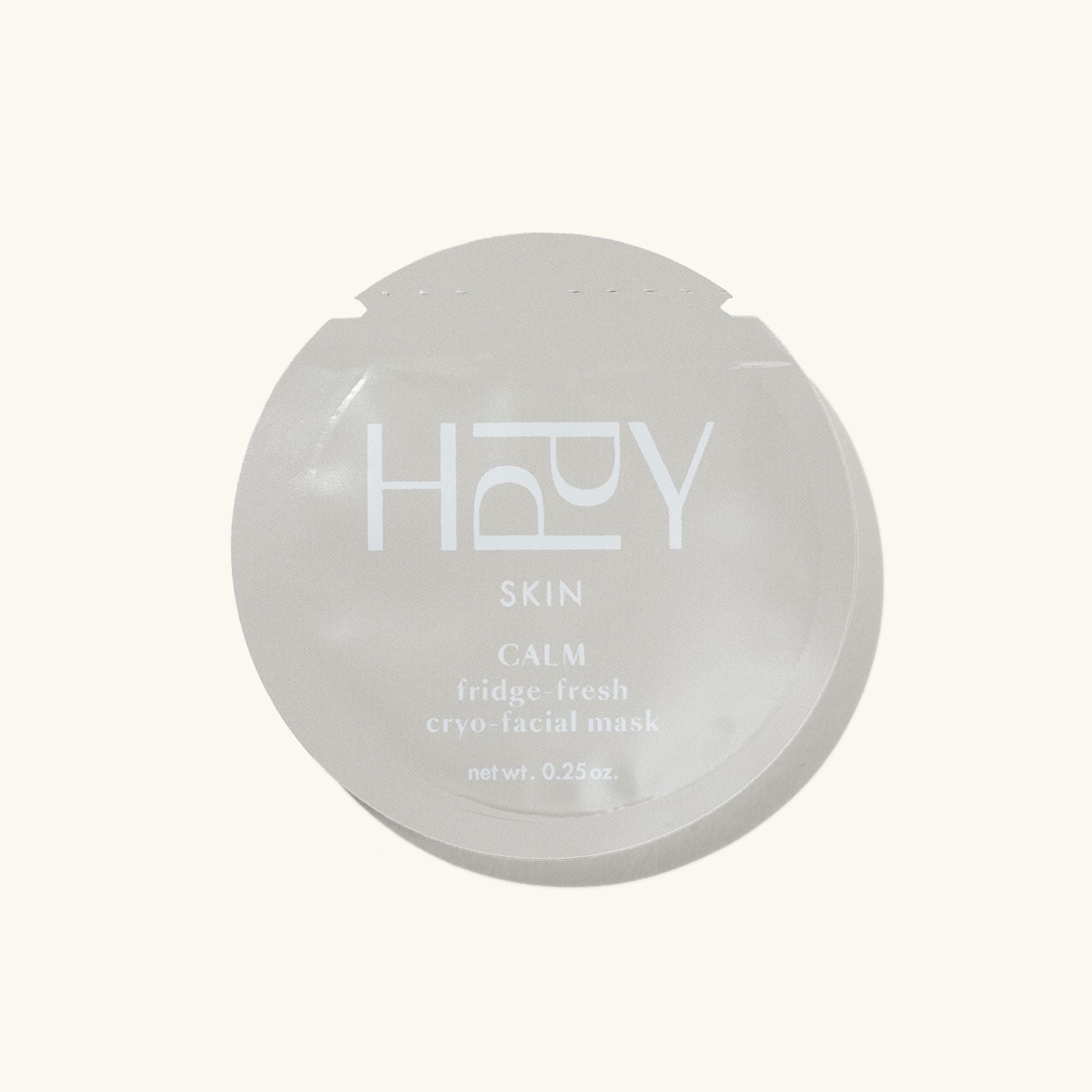 Round gray facial mask packaging with 'HPPY' branding on a white background