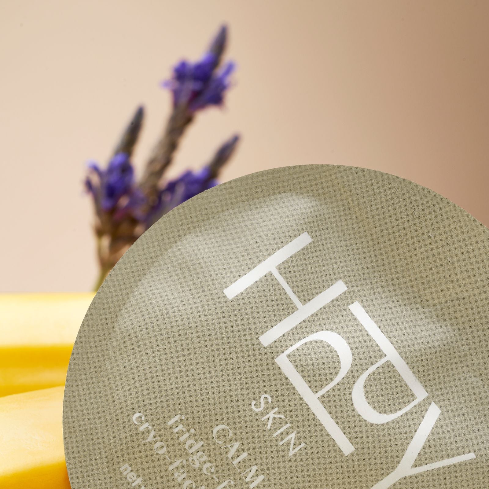 Round product with 'HPPY' branding on a beige background with lavender.