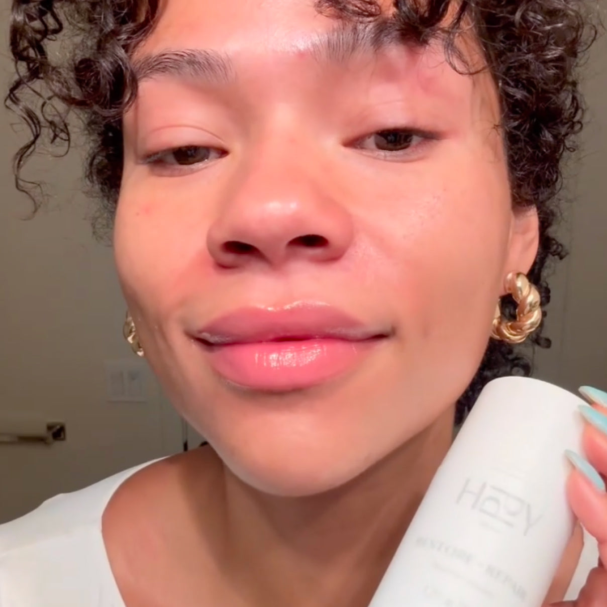 Person holding a white hair dryer with a neutral background