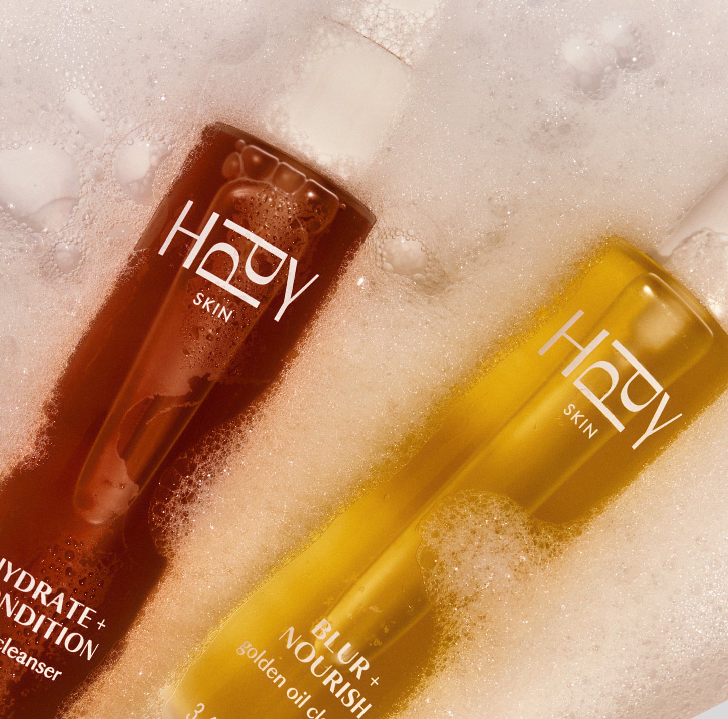 Two bottles of Hopy Skin products on a textured surface with bubbles.
