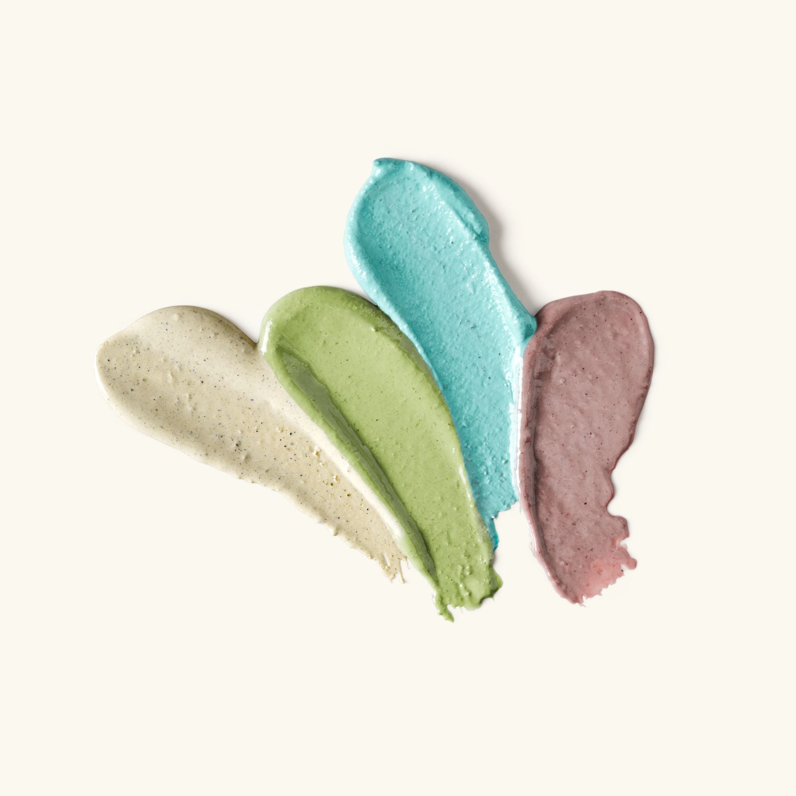 Four swatches of different colored creams on a white background