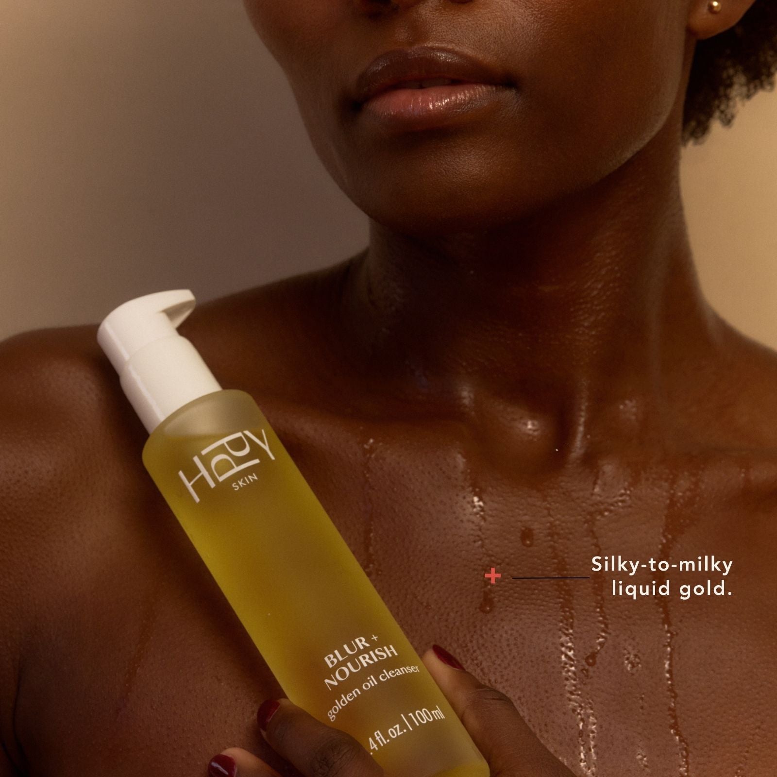 Woman holding a bottle of Hery Skyn product with visible texture on skin.