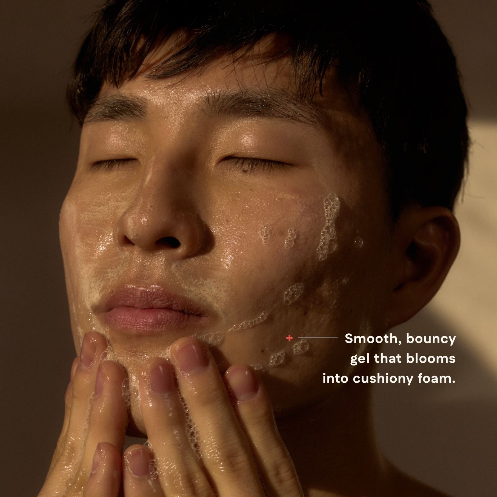 Person applying a smooth, bouncy gel to their face with text describing its texture.