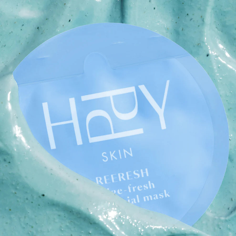 Blue facial mask with 'HPPY' branding on a green background