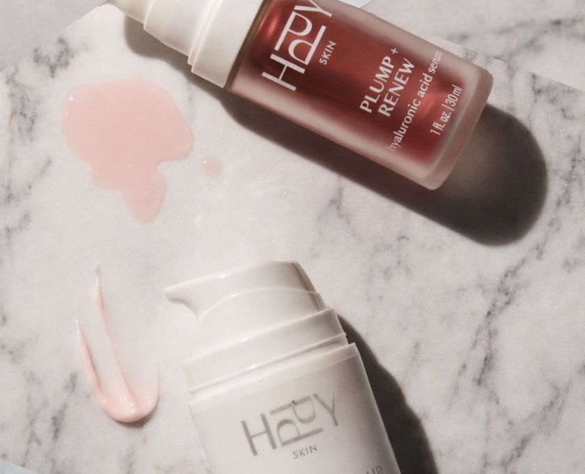 HPPY skincare serum bottle on a marble surface