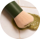 Makeup brush with green handle