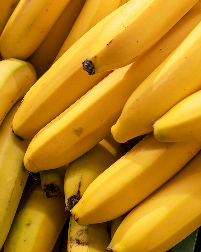 Close-up of a bunch of yellow bananas with some brown spots.
