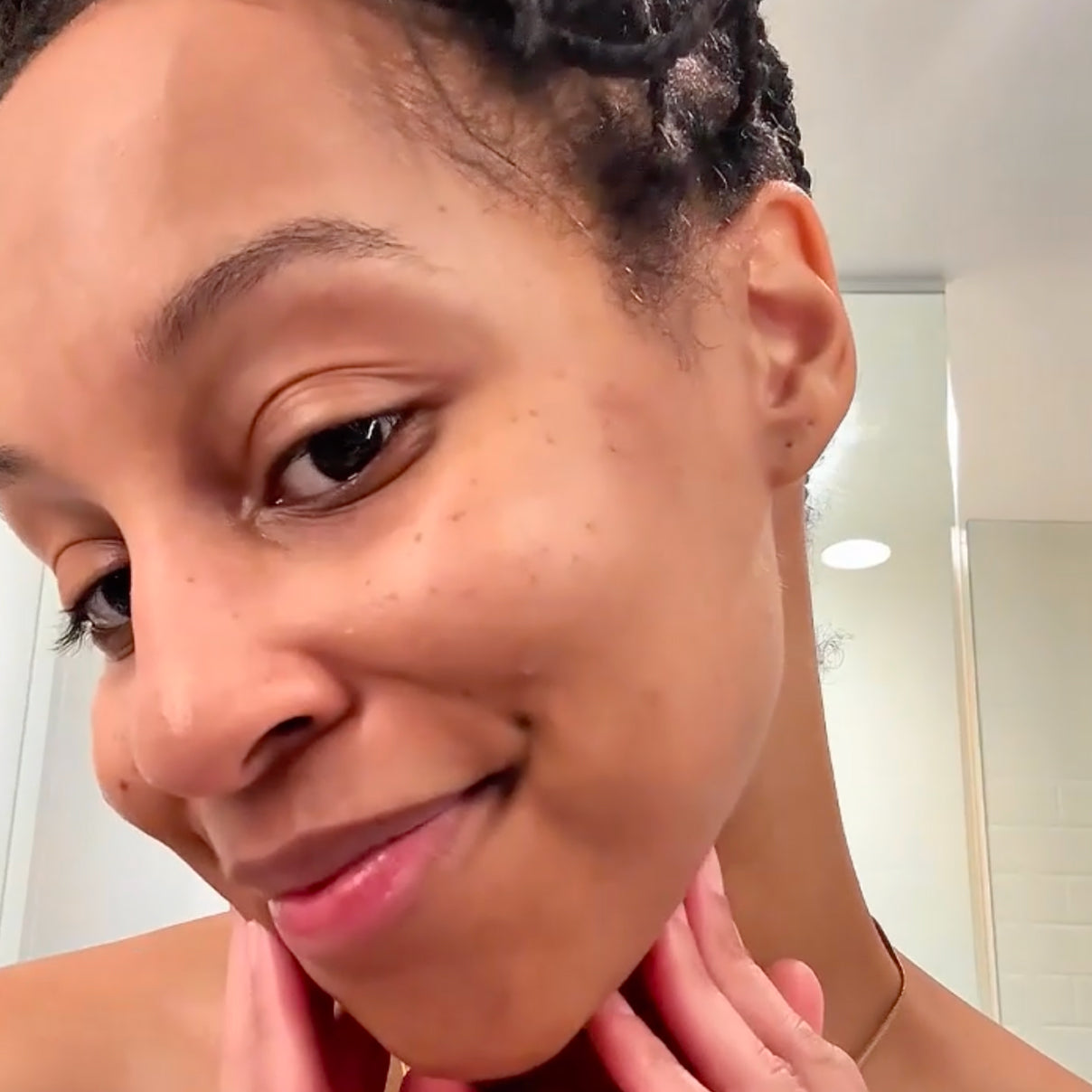 Woman touching her face in a bathroom setting