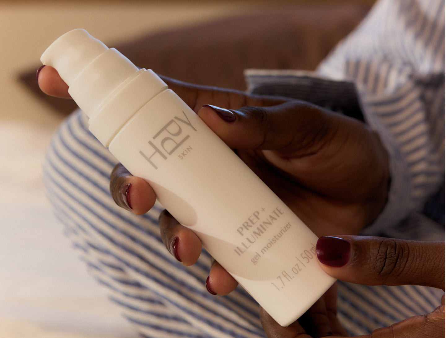 Hand holding a HPPY skincare product with a blurred background