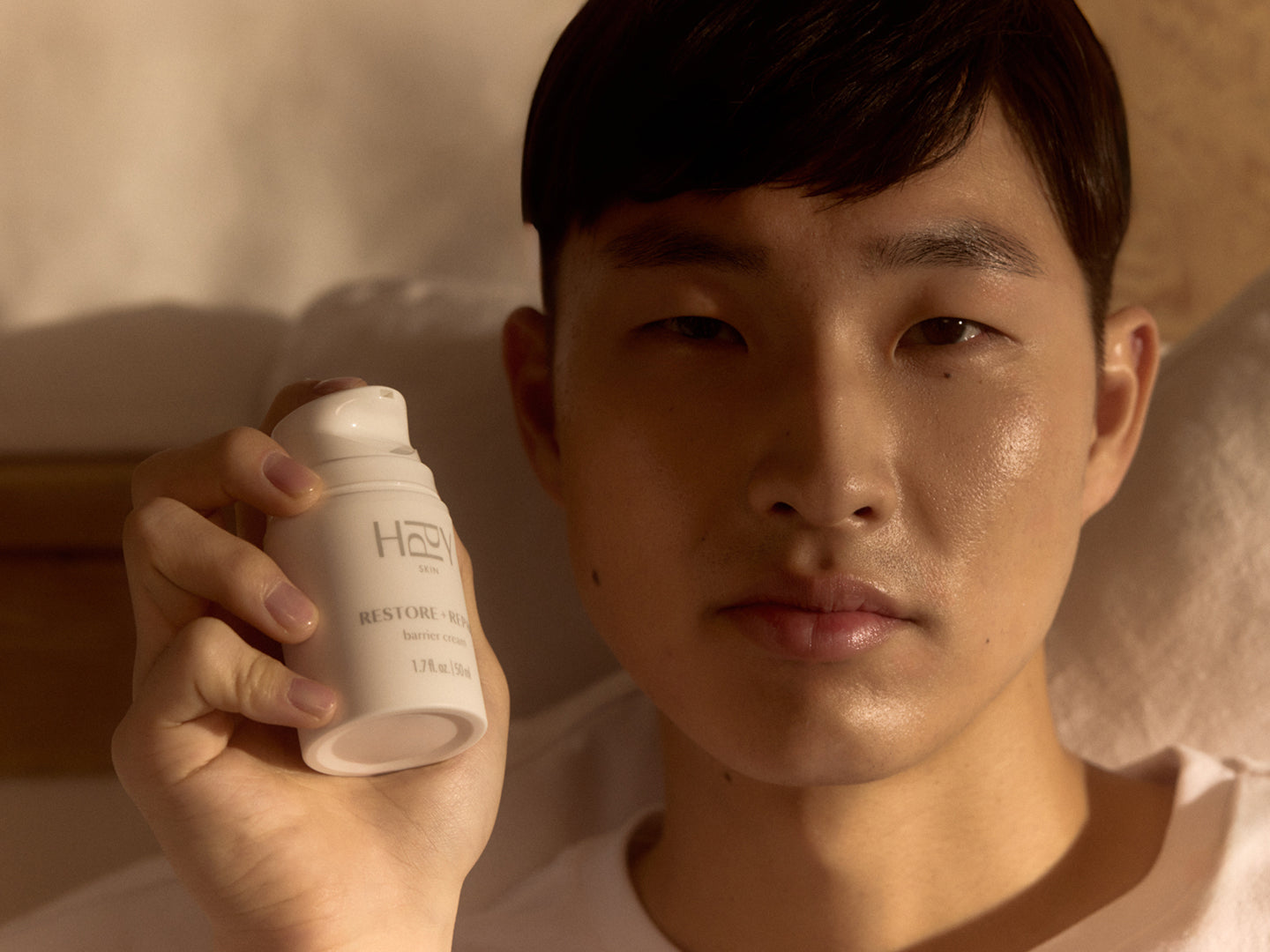 Man holding a white container with 'HPPY' branding against a neutral background