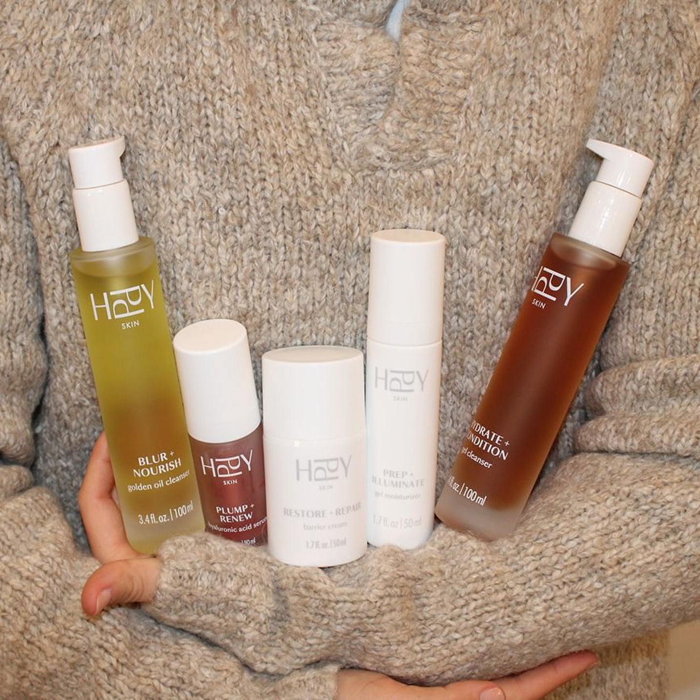 Collection of HPPY skincare products on a textured surface