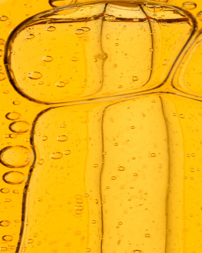 Close-up of vitamin e oil showing bubbles in a  golden color 