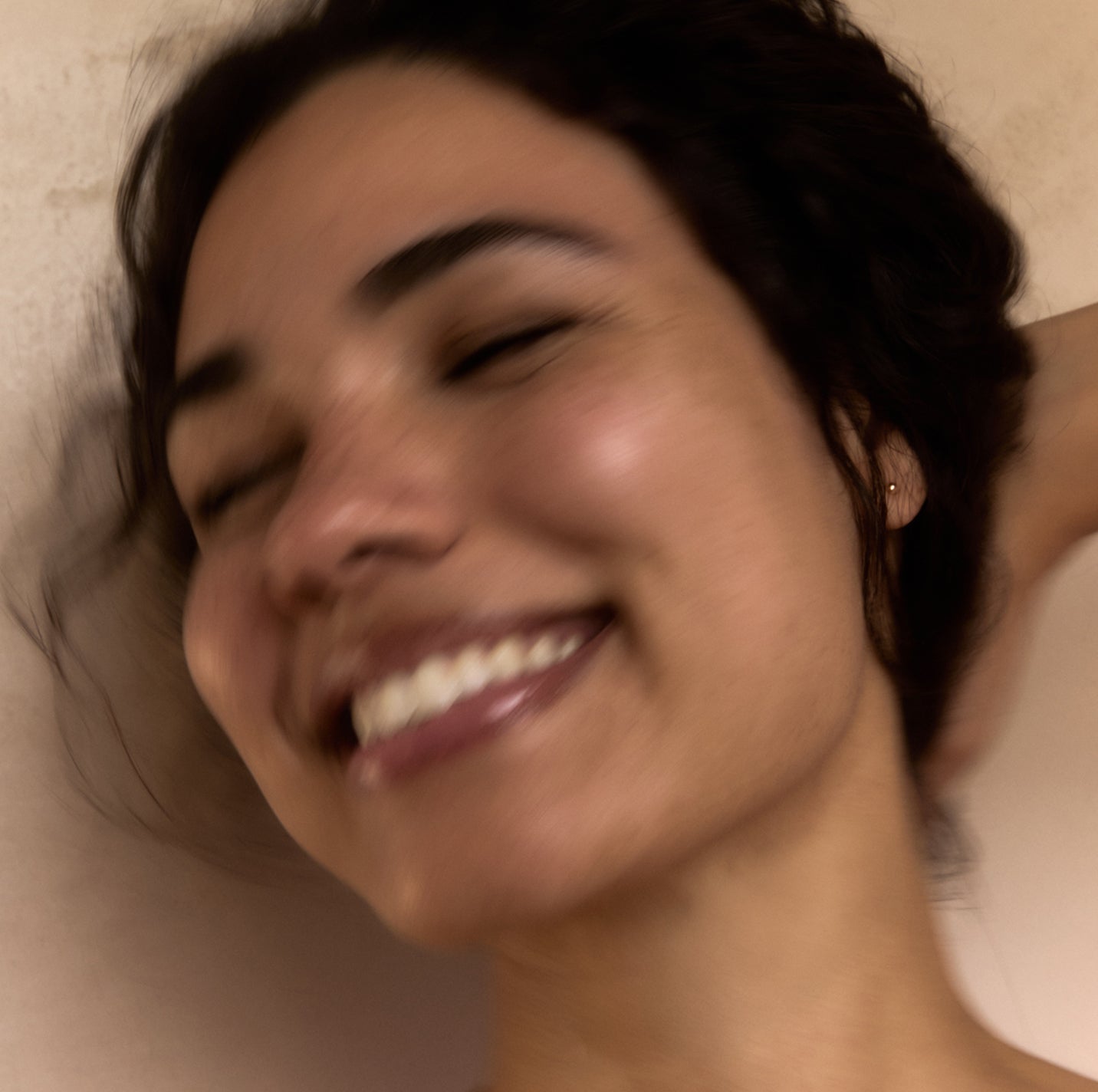 Close-up of a woman with a warm smile against a neutral background